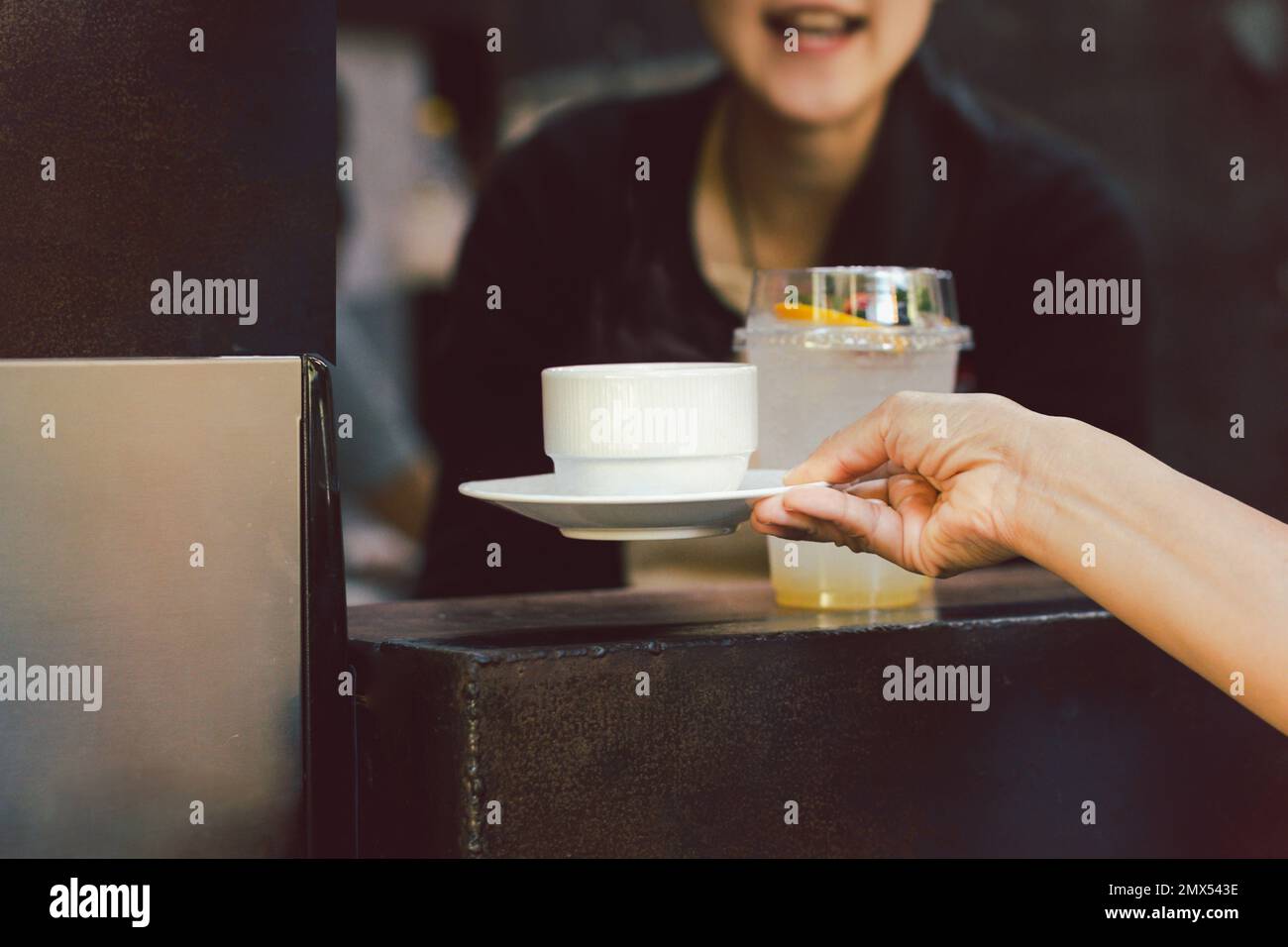 Femme Barista servant une tasse de café au café. Banque D'Images