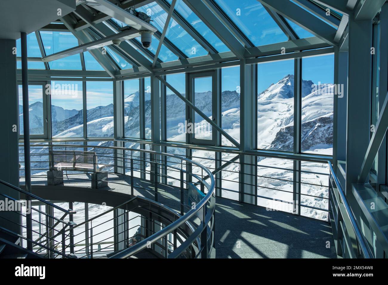 Intérieur architectural en verre et en métal avec ombres et vue alpine enneigée - horizontale Banque D'Images