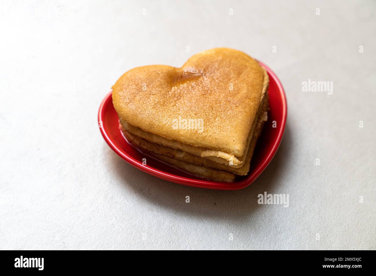 Une crêpe en forme de coeur dans une soucoupe en forme de coeur rouge sur  une surface plane et transparente - concept de la Saint-Valentin Photo  Stock - Alamy