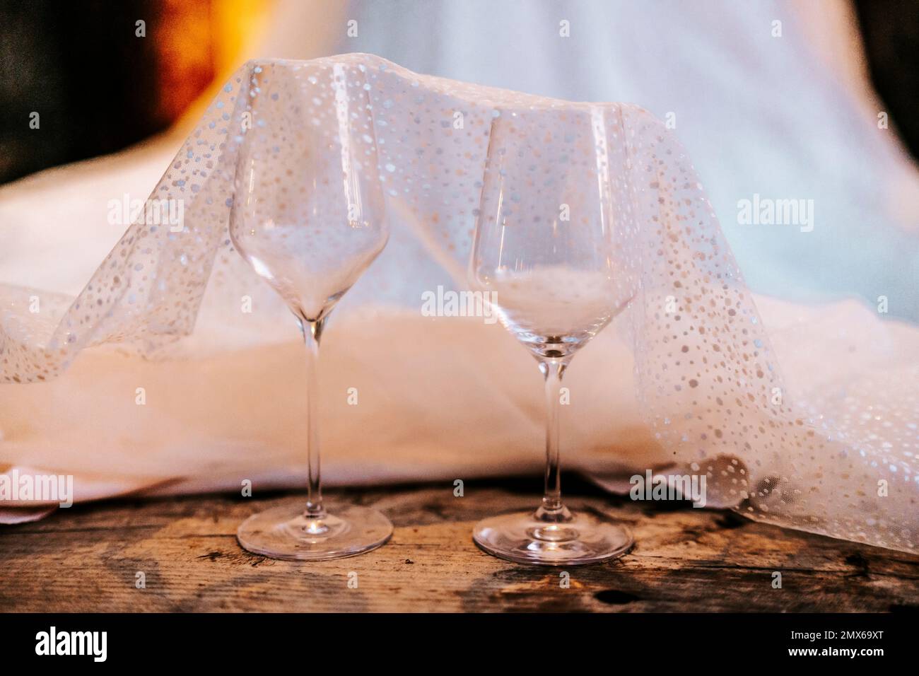 Deux verres à vin disposés avec robe de mariage sur parquet Banque D'Images