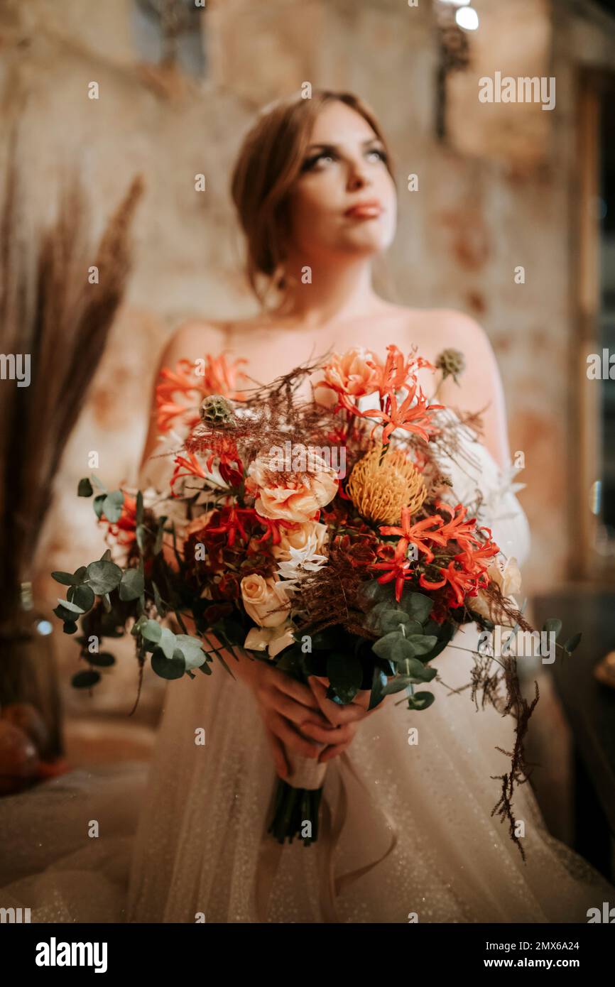 Portrait de la belle mariée avec un bouquet dans un cadre rustique Banque D'Images