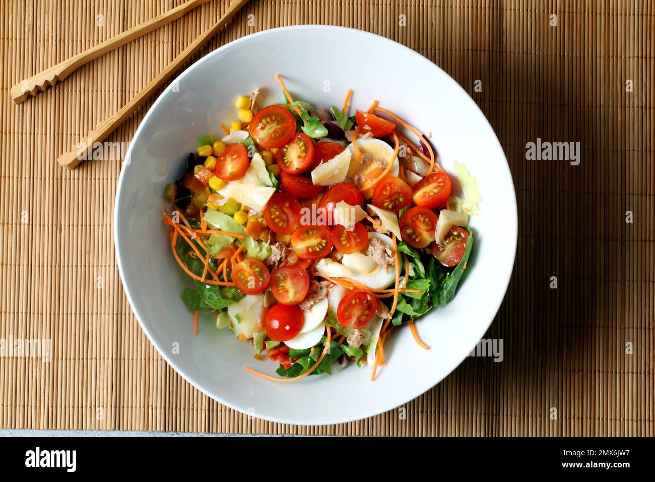 Salade mélangée avec tomates cerises dans un bol blanc. Banque D'Images