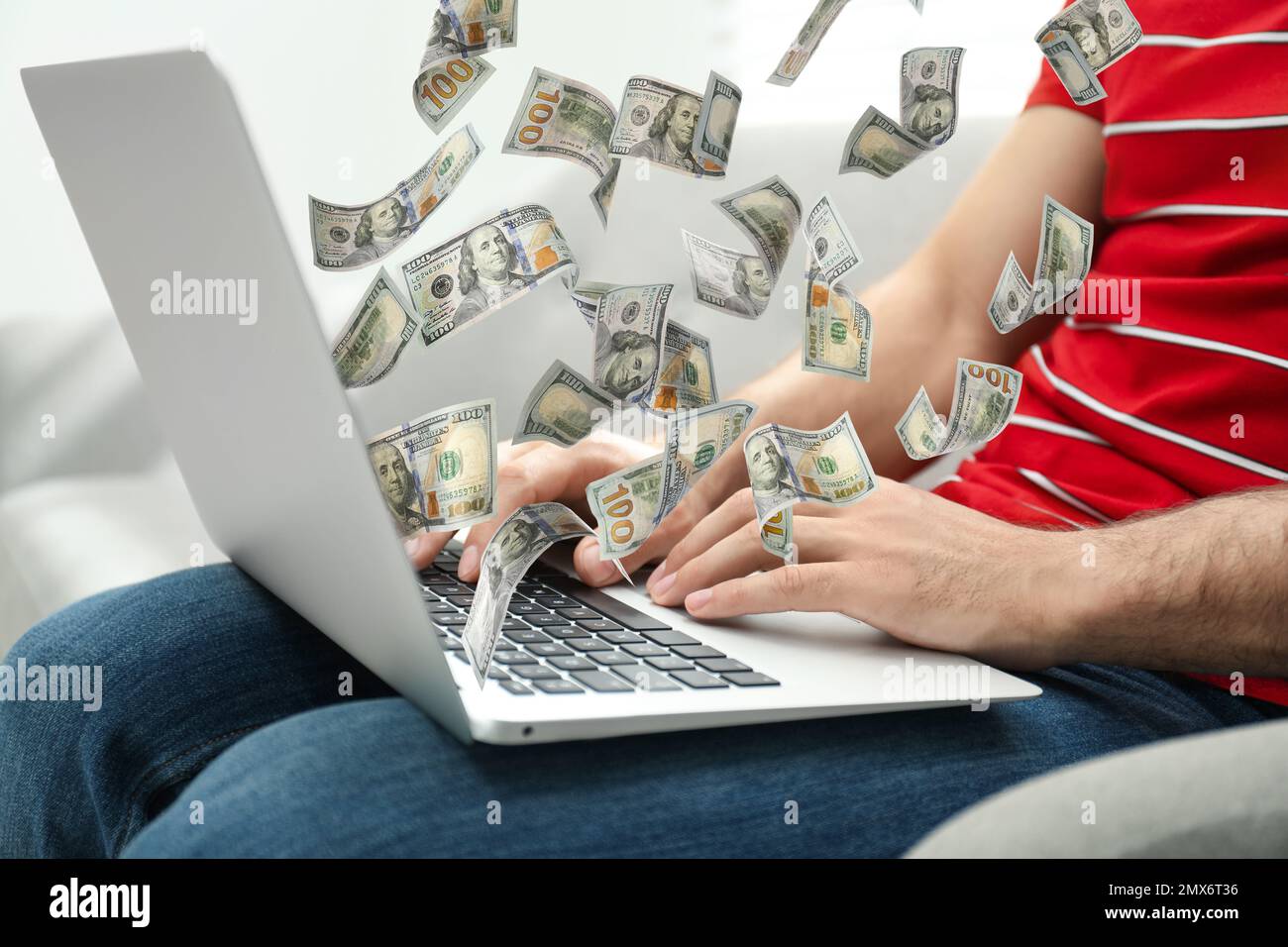 Homme avec un ordinateur portable moderne et des billets de banque en dollars à la maison, en gros plan. Les gens font de l'argent en ligne Banque D'Images