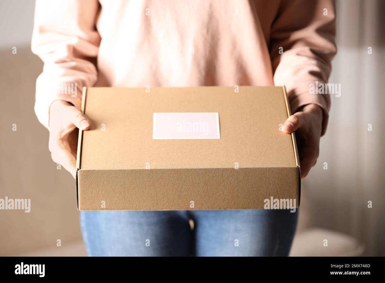 Femme avec boîte en carton fermée à la maison, gros plan Photo Stock - Alamy