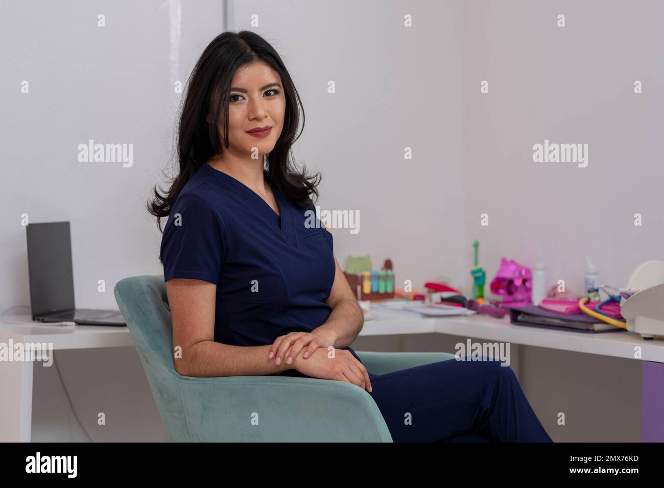 Jeune médecin mexicain, assis au bureau de son bureau, regardant la caméra, avec un espace de copie. Banque D'Images