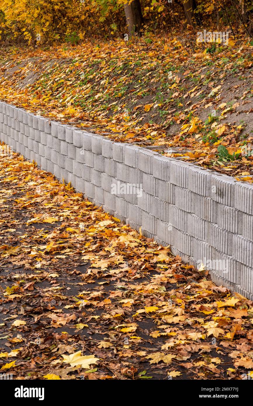 Un mur de soutènement composé d'éléments en béton protège la chaussée et la chaussée contre le glissement sur la pente. Banque D'Images