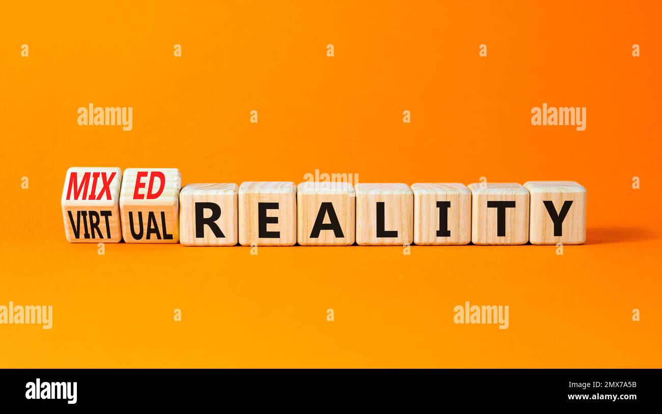 Symbole de réalité mixte ou virtuelle. Mots-clés réalité mixte réalité virtuelle sur des cubes en bois. Belle table orange fond orange. Entreprises mixtes Banque D'Images