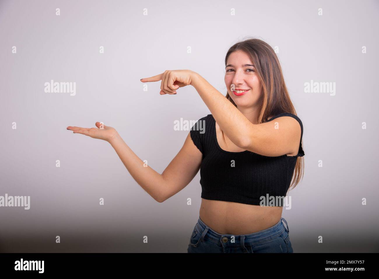 Belle fille pointe à l'espace au-dessus de sa main avec son index, publicité photo Banque D'Images