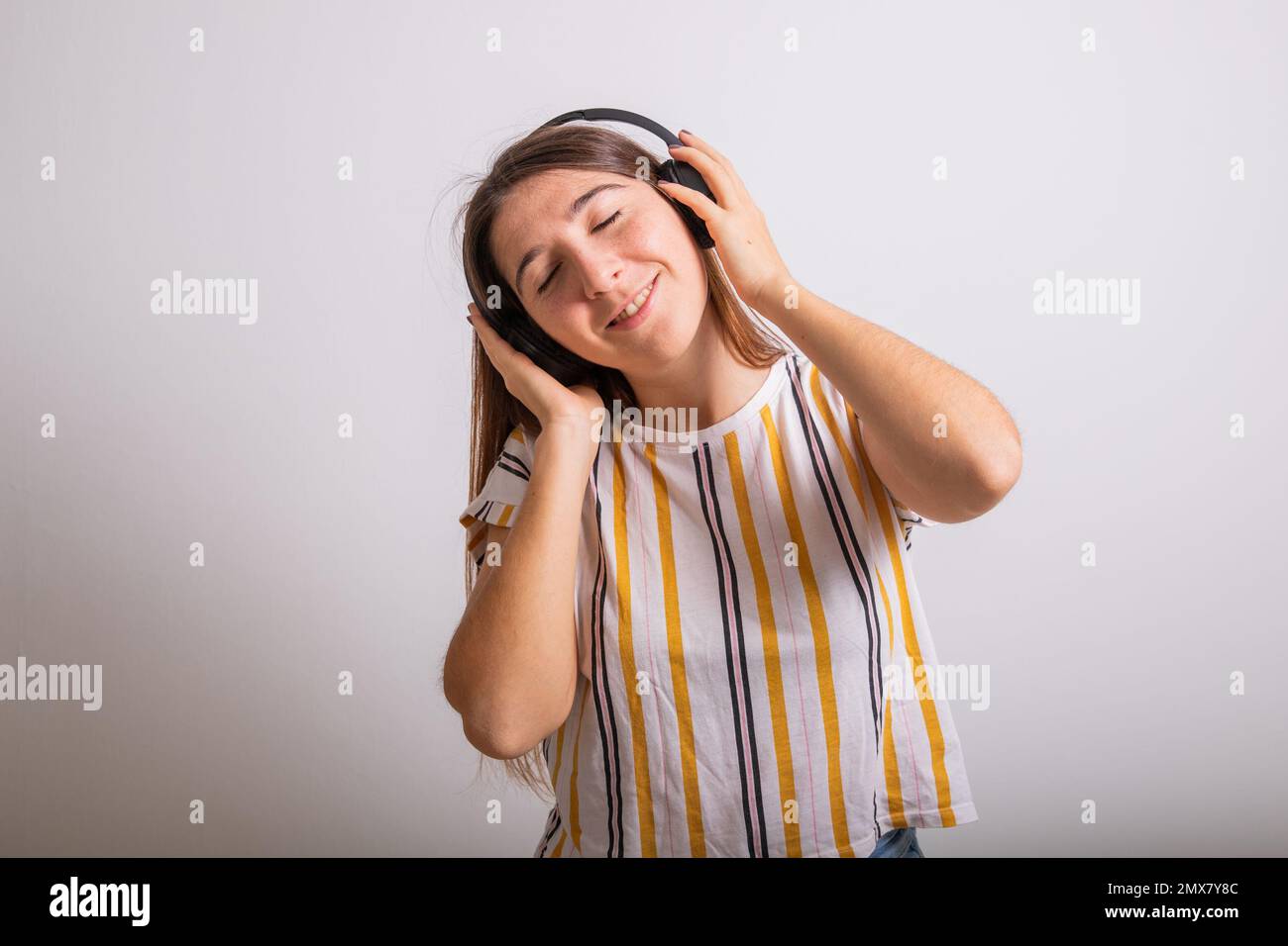 Portrait en studio d'une femme insouciante qui écoute de la musique avec son casque Banque D'Images