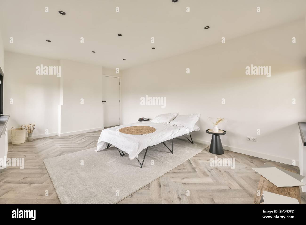 Intérieur d'une chambre moderne avec mobilier minimaliste, moquette sur murs blancs et parquet Banque D'Images