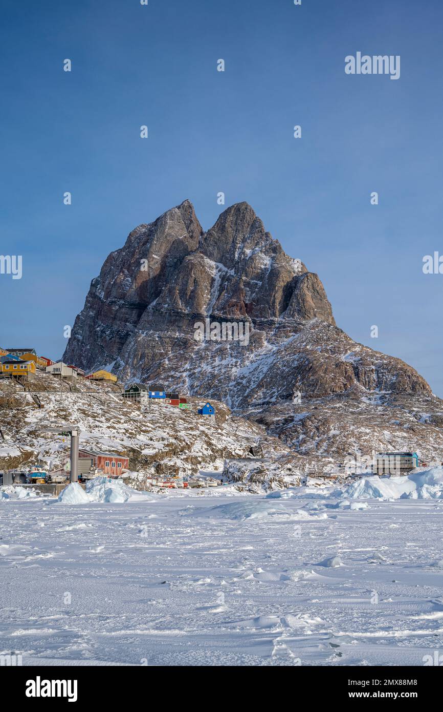 Maisons colorées accrochant sur le flanc de la montagne à Uummannaq dans l'ouest du Groenland Banque D'Images