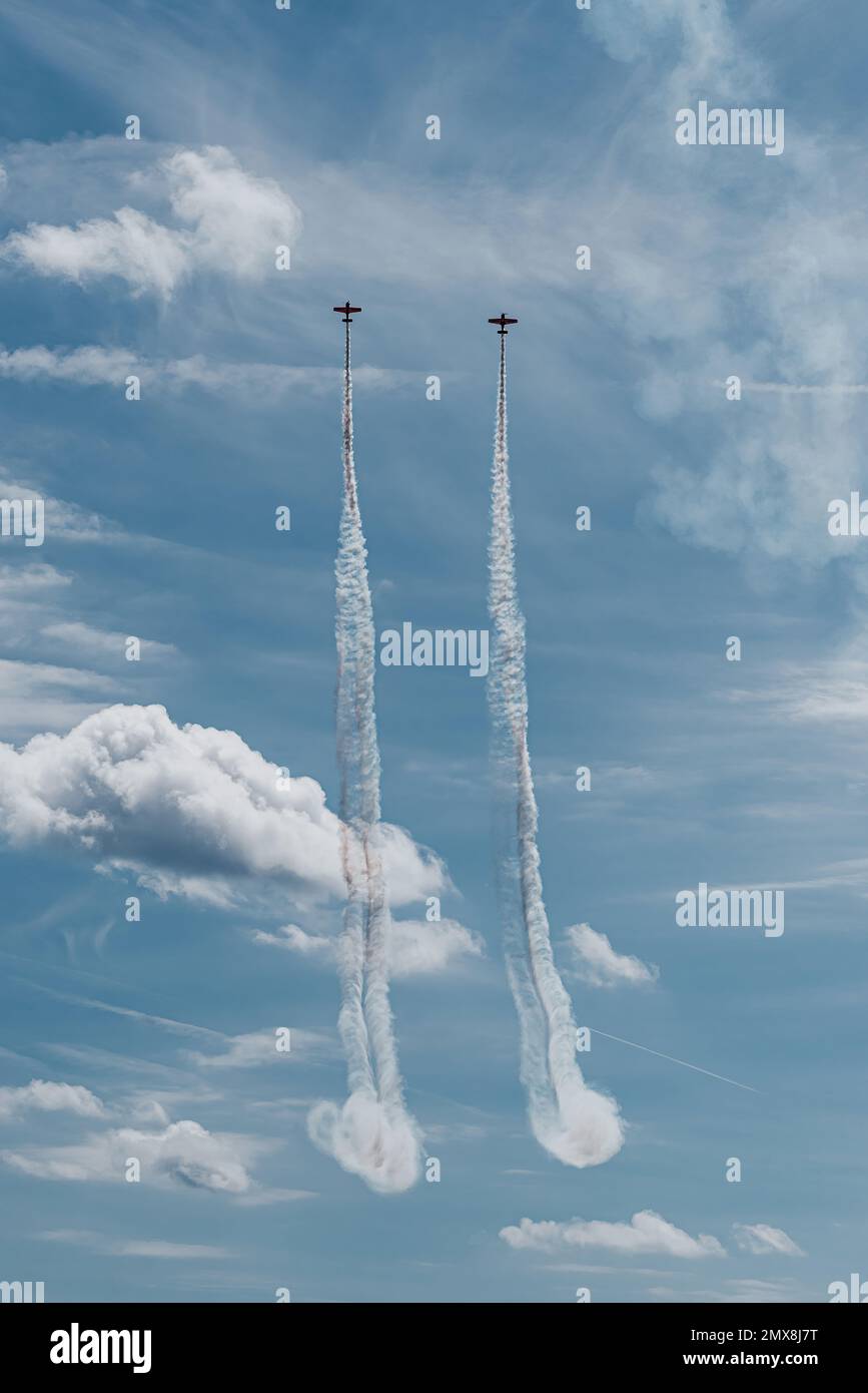 deux avions légers montent en parallèle, laissant derrière eux un sentier blanc au-dessus du ciel bleu. des sentiers de condensation. concept ensemble et attention Banque D'Images