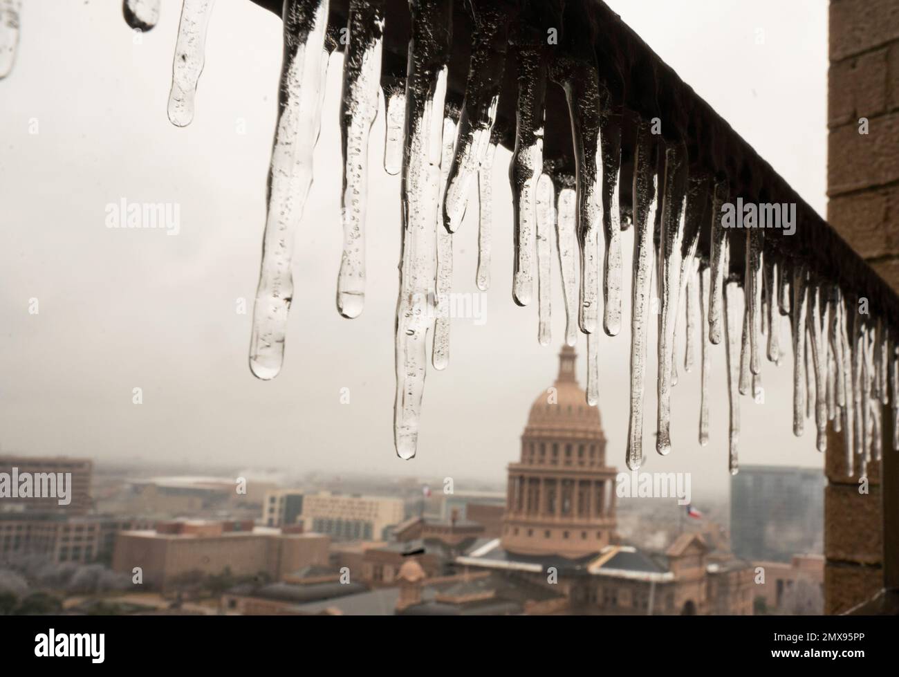 Austin Texas États-Unis, 1 février 2023 : les glaces s'écoulent d'un balcon avec le capitole du Texas en arrière-plan tandis qu'Austin et le centre du Texas se rétablissent d'une tempête de glace qui a renversé l'électricité à des milliers et a causé des dommages aux arbres dans toute la ville. Environ un tiers d'Austin est sans pouvoir deux jours après le coup de tempête. Crédit : Bob Daemmrich/Alay Live News Banque D'Images