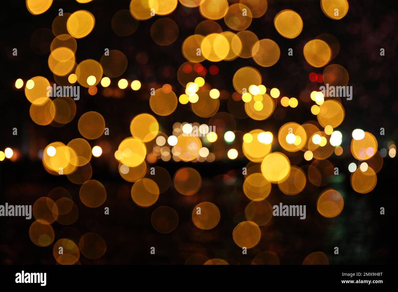 Vue floue de belles lumières sur fond noir. Ambiance festive Banque D'Images