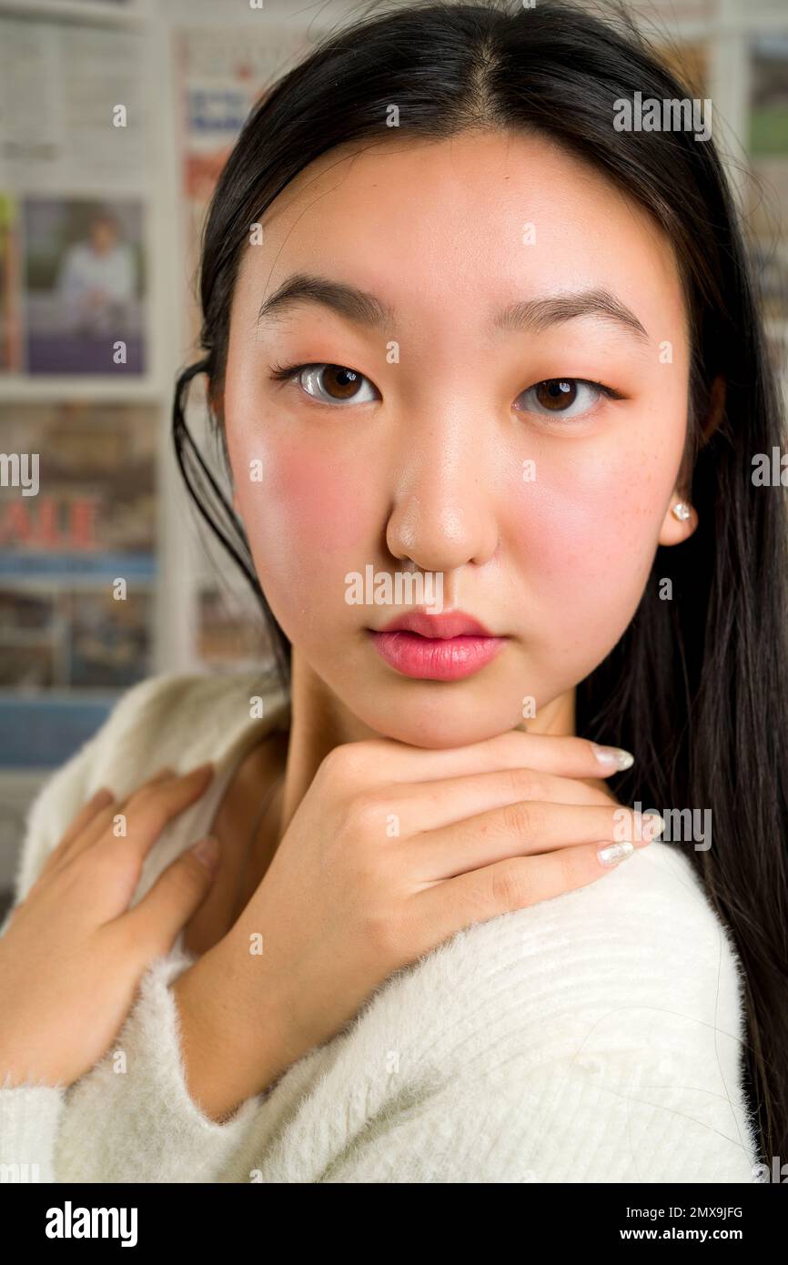 Gros plan portrait de la belle adolescente asiatique avec les mains encadrant le visage Banque D'Images