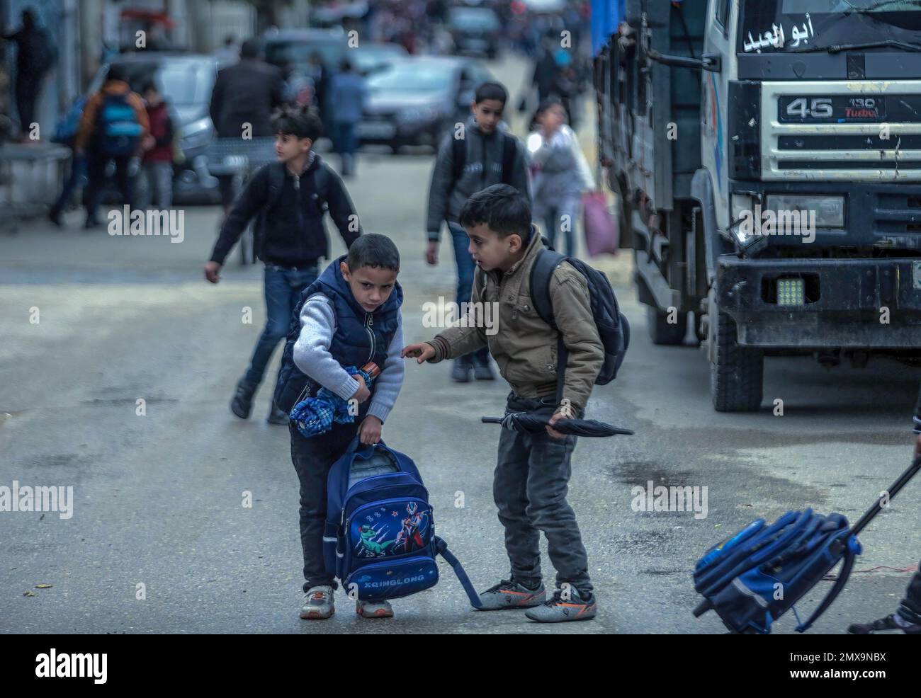Les étudiants palestiniens qui sortent de l'école rentrent chez eux par mauvais temps dans la ville de Gaza. Banque D'Images