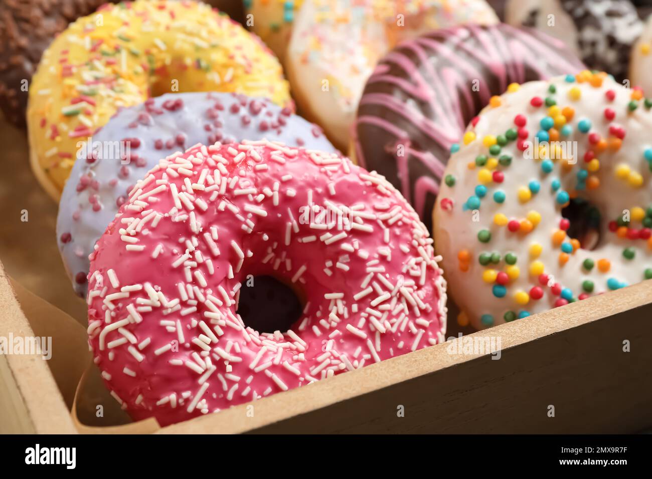 Beignets délicieux avec saupoudrer dans une boîte, gros plan Banque D'Images