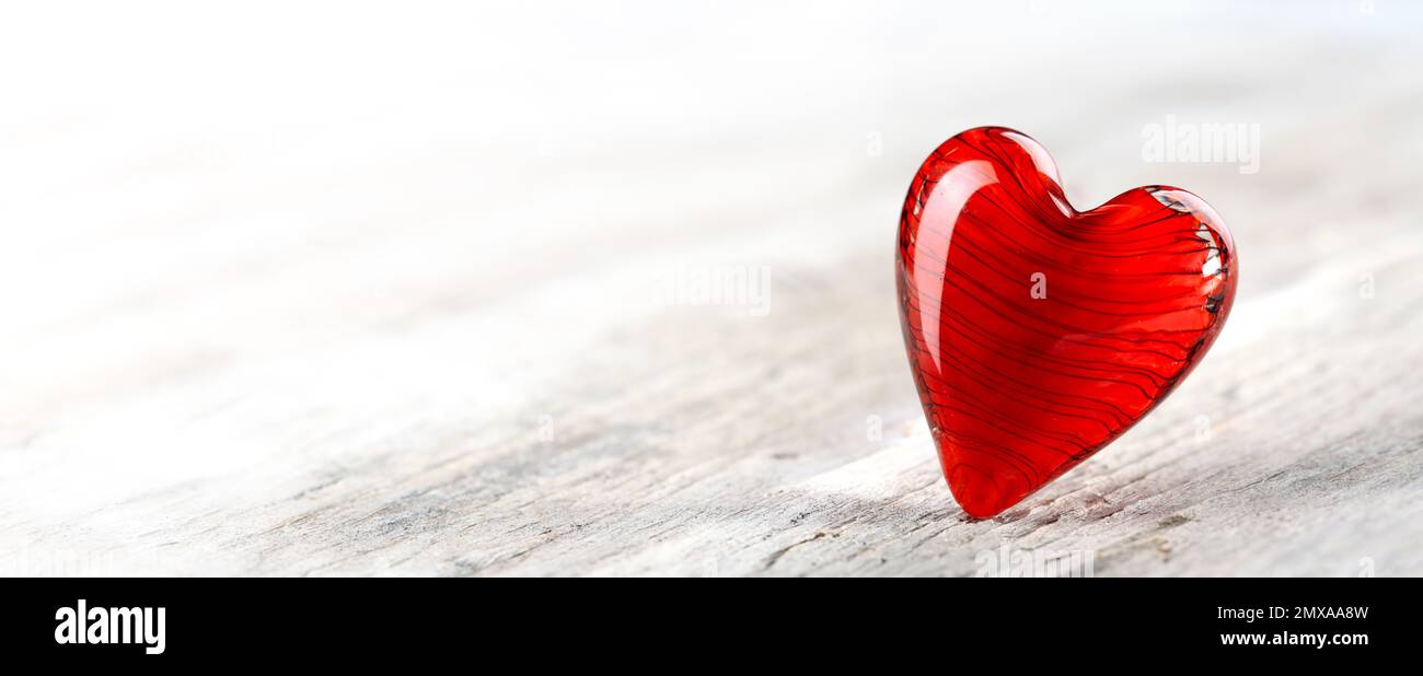 Cœur de jour de la Saint-Valentin rouge rubis sur un sol en bois blanc. Pour la Saint-Valentin, l'amour et le romantisme. Banque D'Images