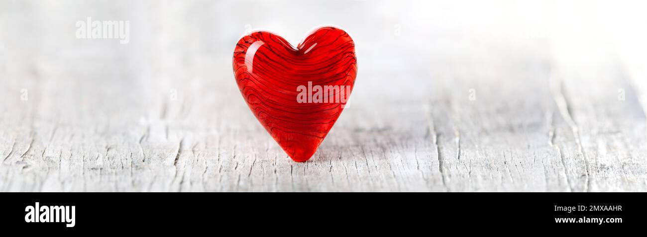 Cœur de jour de la Saint-Valentin rouge rubis sur un sol en bois blanc. Pour la Saint-Valentin, l'amour et le romantisme. Banque D'Images