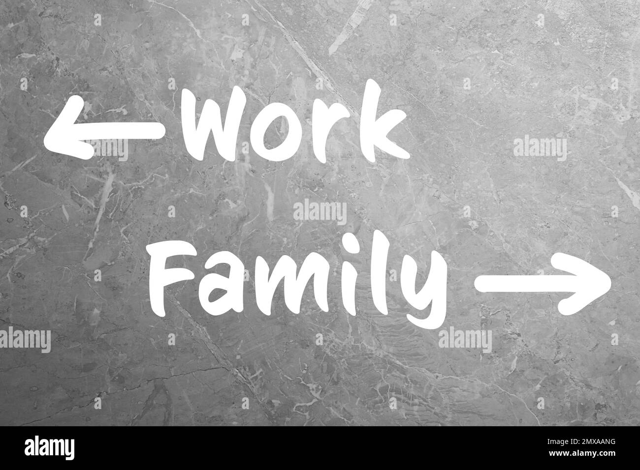 Le choix de la vie. Flèches avec des mots travail et famille sur fond de pierre grise Banque D'Images