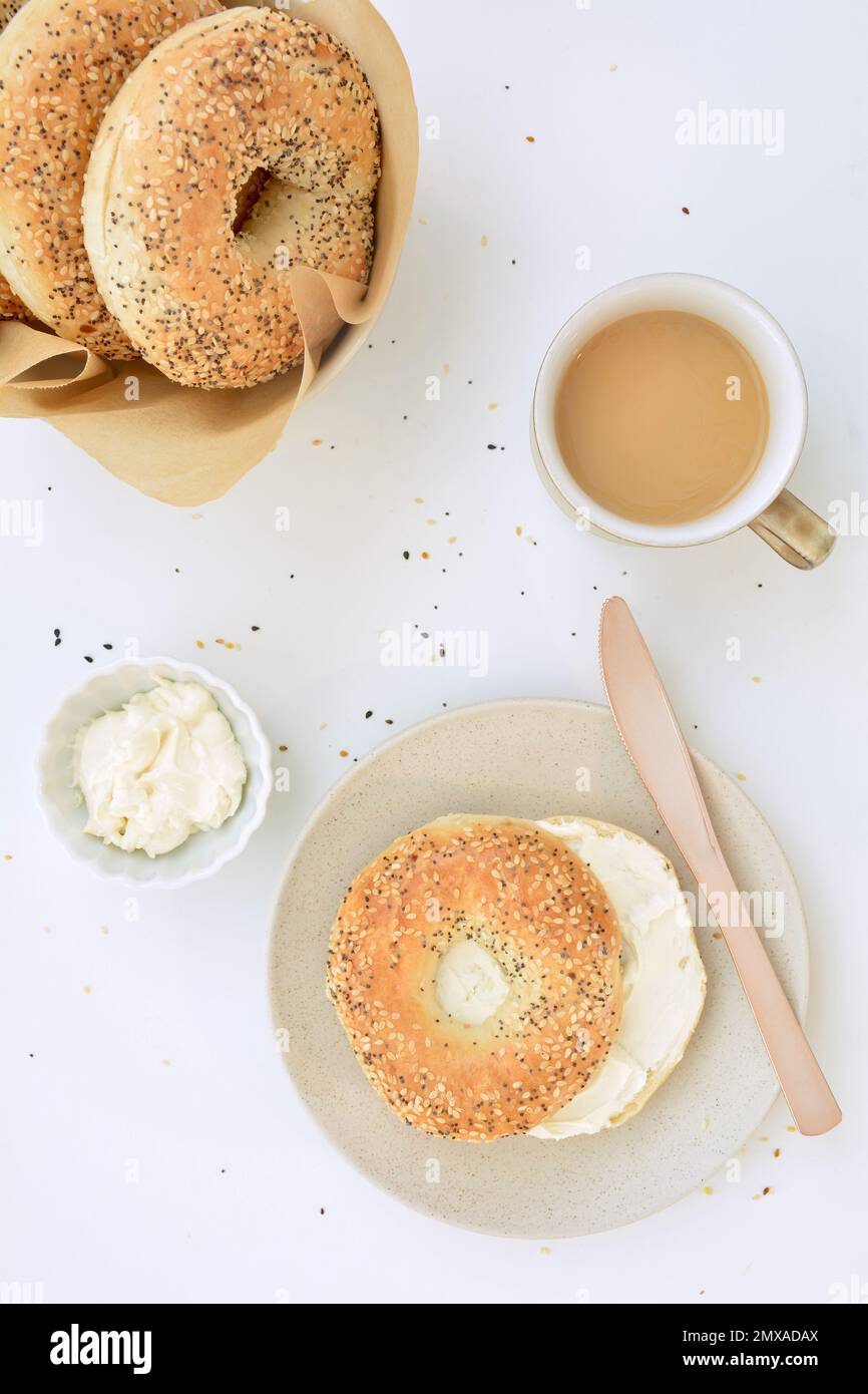Bagels aux graines avec fromage à la crème et café en format plat. Petit déjeuner sain et nutritif. Banque D'Images