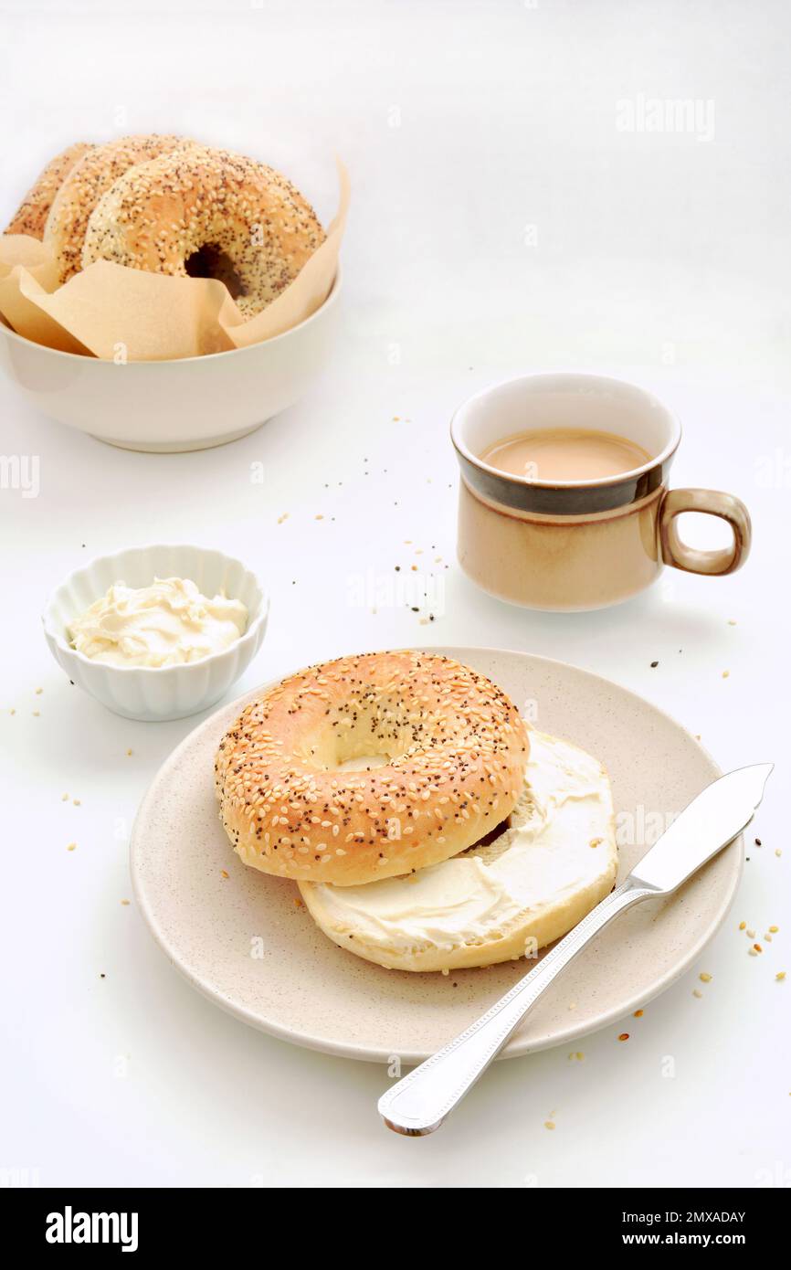 Bagels aux graines avec fromage à la crème et café en format vertical. Petit déjeuner sain et nutritif. Banque D'Images