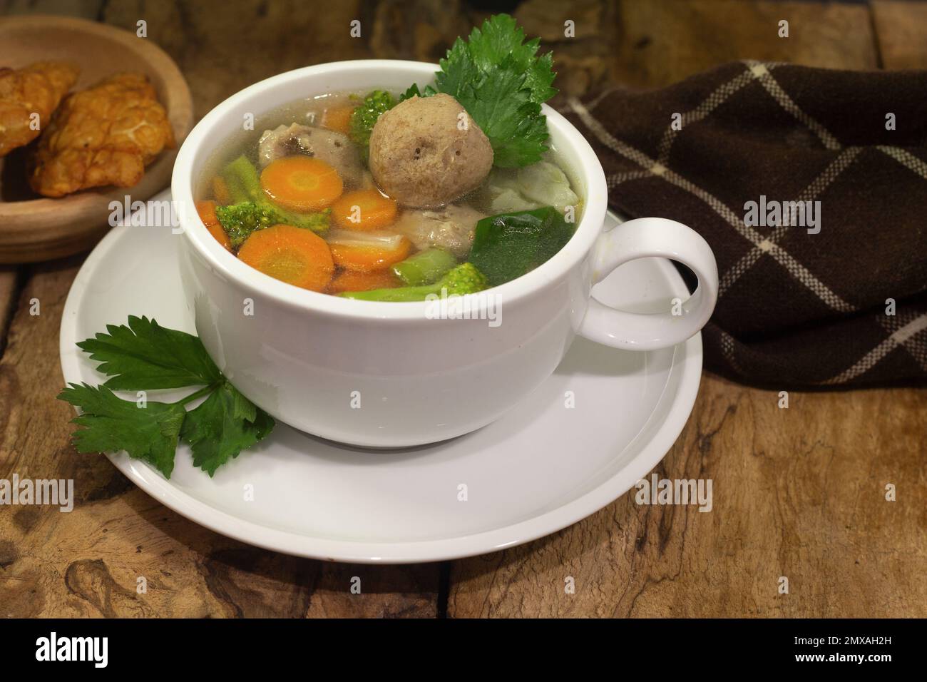 soupe de légumes et de boulettes de viande avec accompagnement de tempeh sur fond de bois ancien Banque D'Images
