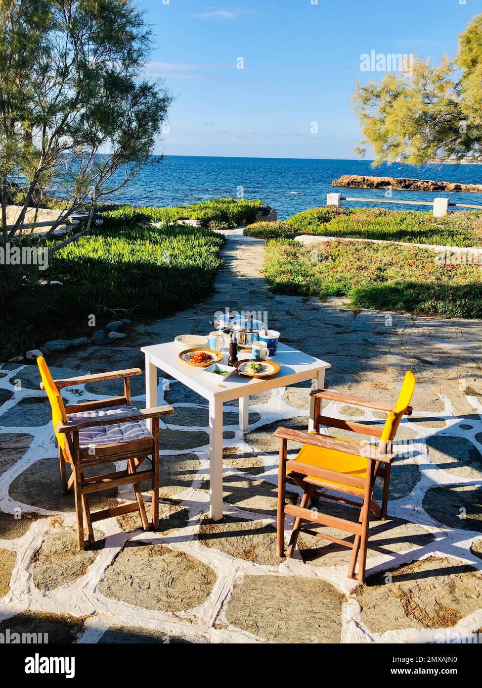 Terrasse avec vue sur la mer, table et deux chaises avec dîner, Paros, Cyclades, Grèce Banque D'Images