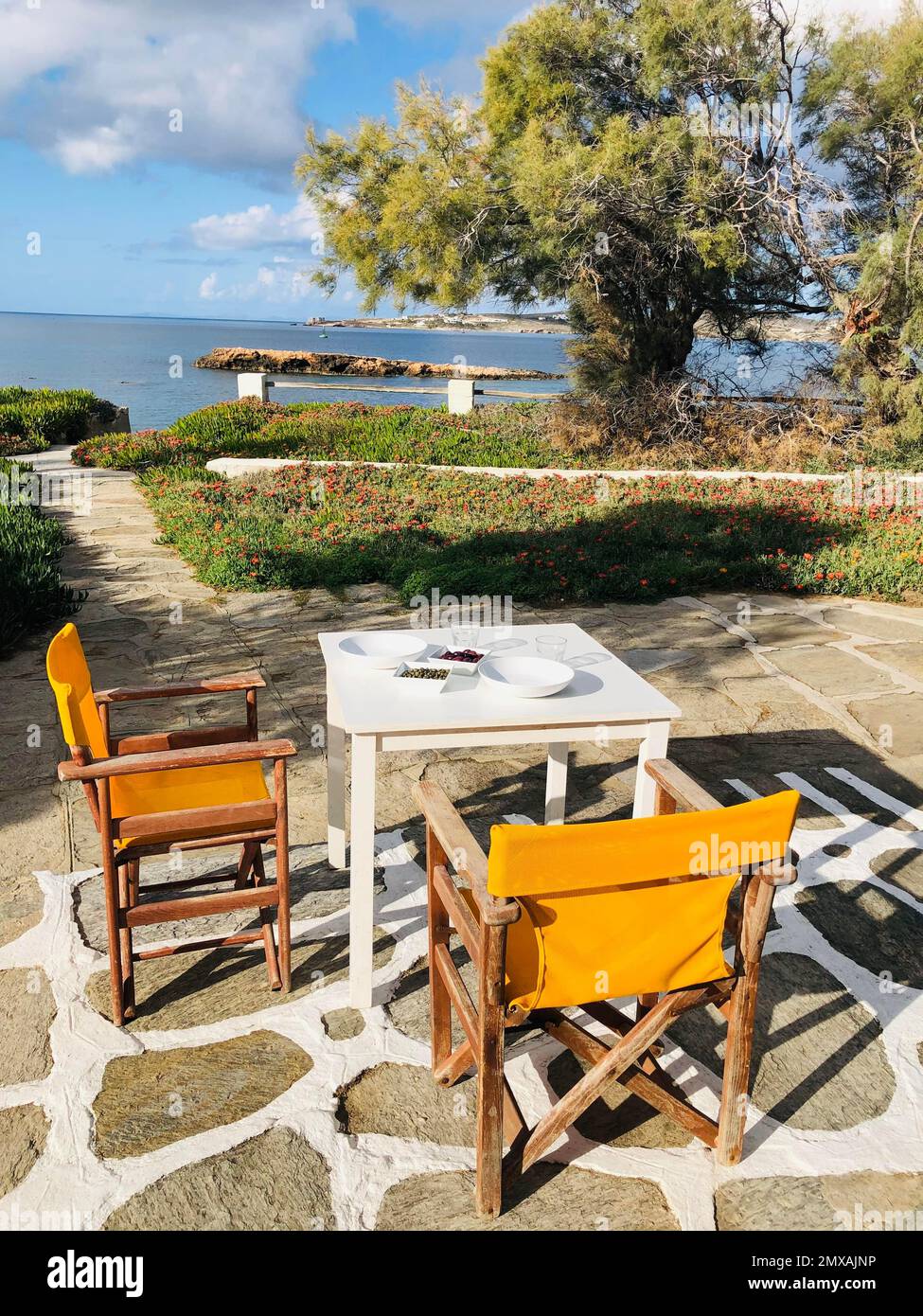 Terrasse avec vue sur la mer, table avec olives et câpres et deux chaises, Paros, Cyclades, Grèce Banque D'Images