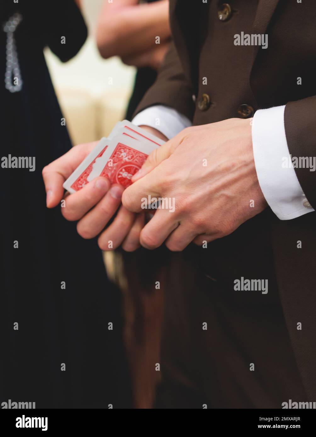Illusionniste magicien avec un jeu de cartes montrant les tours de cartes se concentrer devant les riches invités sur la fête de mariage, le spectacle de jongleur, Banque D'Images