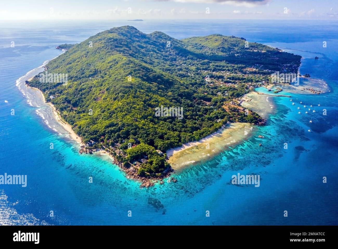 Vue aérienne de l'île de la Digue en plein sud, avec Anse sévère à droite, Plage d'Anse Patates à gauche, et la ville principale de la passe au centre. Banque D'Images