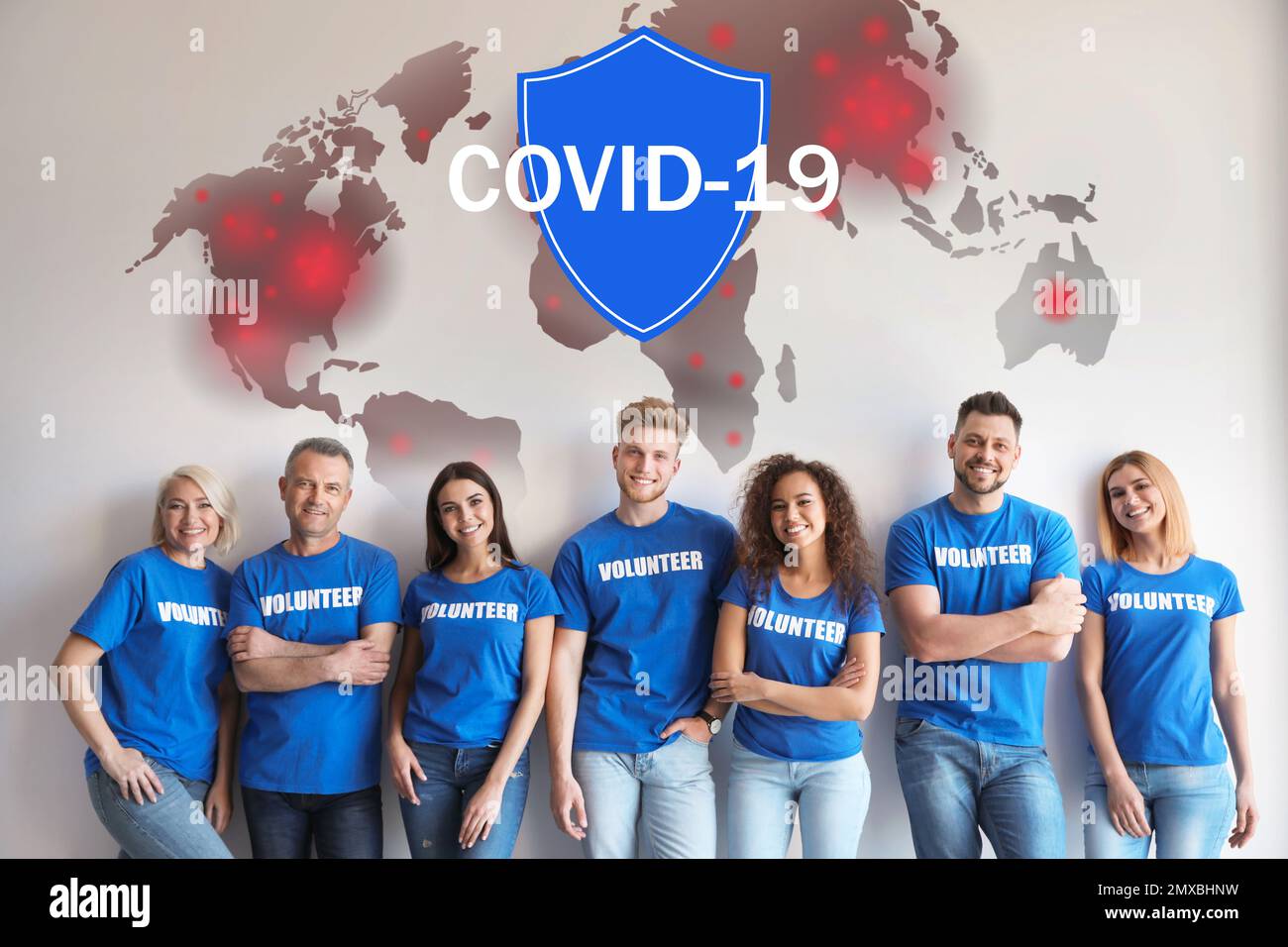 Les bénévoles s'unissent pour aider pendant l'épidémie de COVID-19. Groupe de personnes sur fond clair, carte du monde et illustrations de bouclier Banque D'Images