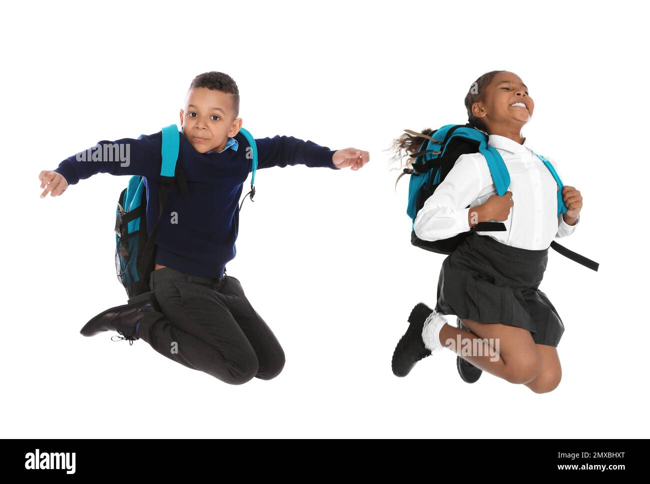 Les enfants afro-américains en uniforme scolaire sautant sur fond blanc Banque D'Images