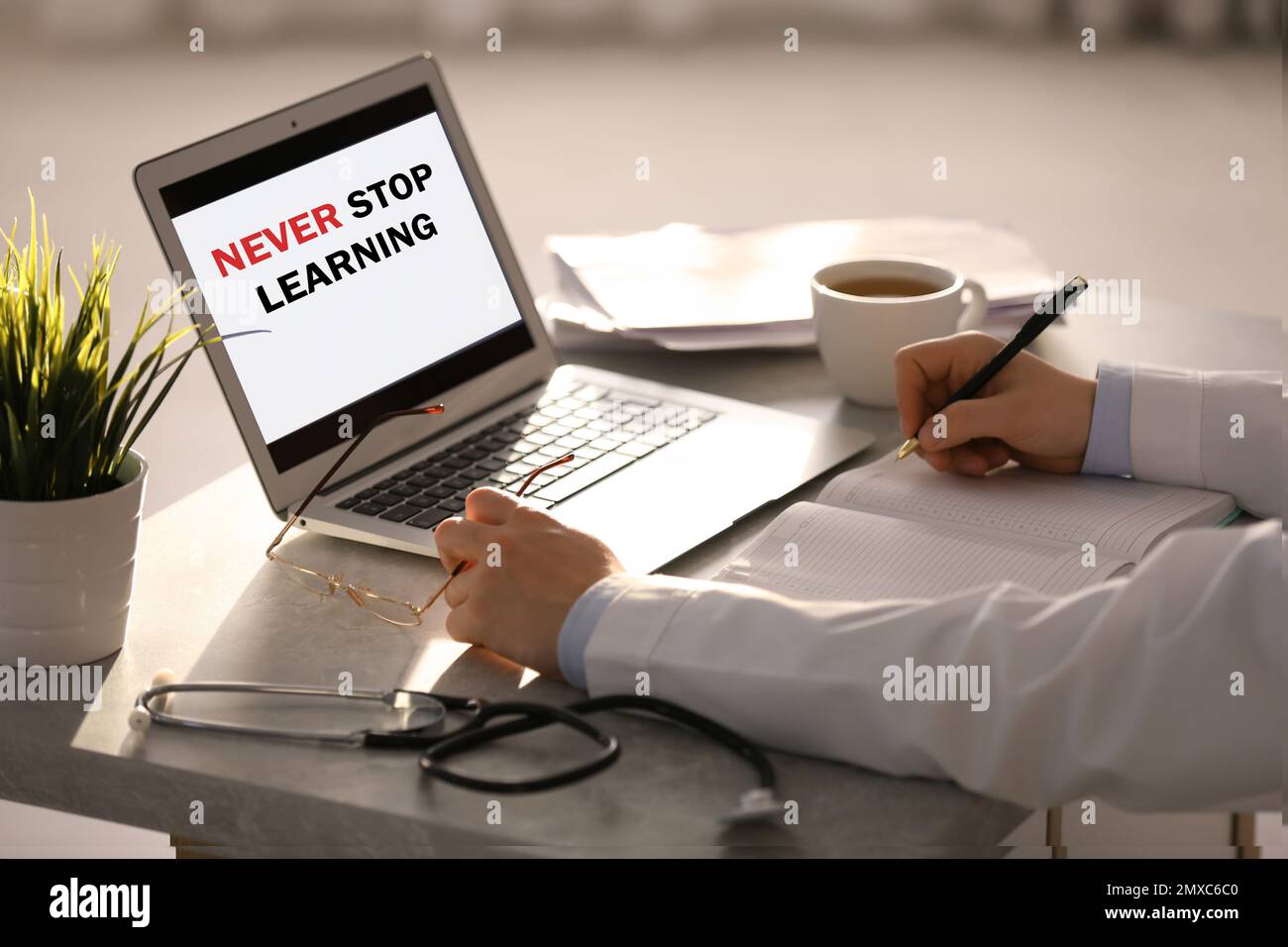 Médecin travaillant avec un ordinateur portable à la table du bureau, en  gros plan. N'arrêtez jamais d'apprendre Photo Stock - Alamy