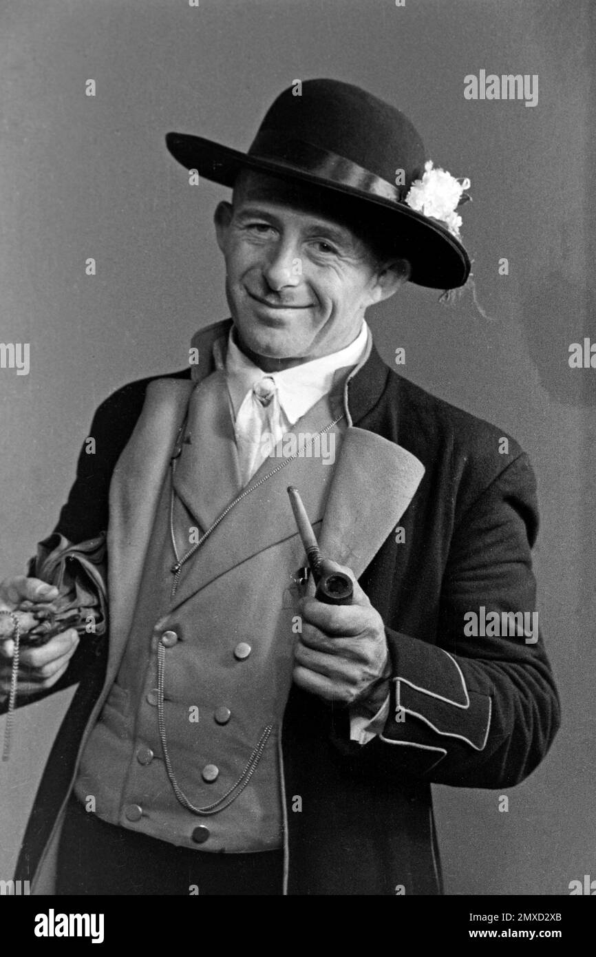 Himmelfahrt, 1938. Homme avec pipe de fumée de la haute Forêt Noire en costume de fête, probablement le jour de l'Ascension, 1938. Banque D'Images