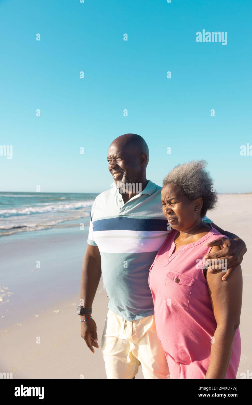 Joyeux couple afro-américain regardant un magnifique paysage marin sous un ciel bleu clair le jour ensoleillé Banque D'Images