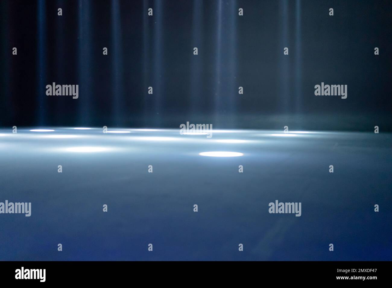 rayons de lumière flous sur le sol de la discothèque. projecteurs au néon bleu blanc. lignes laser et effet d'éclairage. scène vide de nuit en studio avec refle néon Banque D'Images