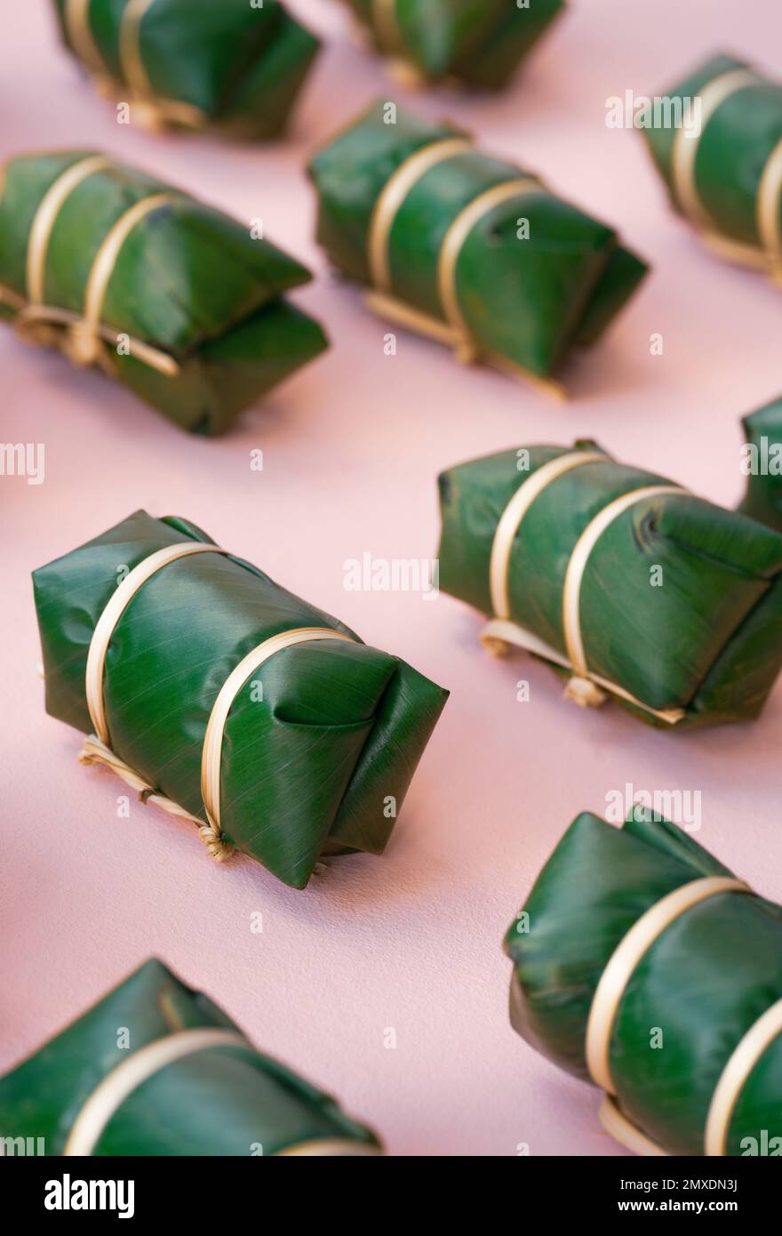 vue du haut thai tradition doux dessert fait avec des haricots noix de coco lait collant riz envelopper par feuille de banane fraîche nature vert mignon paquet bambou sur la broche Banque D'Images