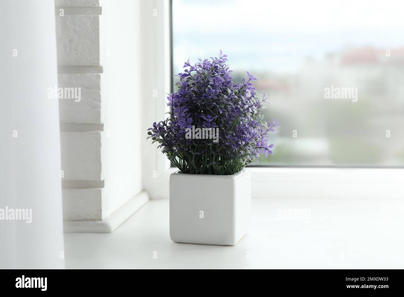 Belle plante artificielle en pot de fleur sur le seuil de la fenêtre Banque D'Images
