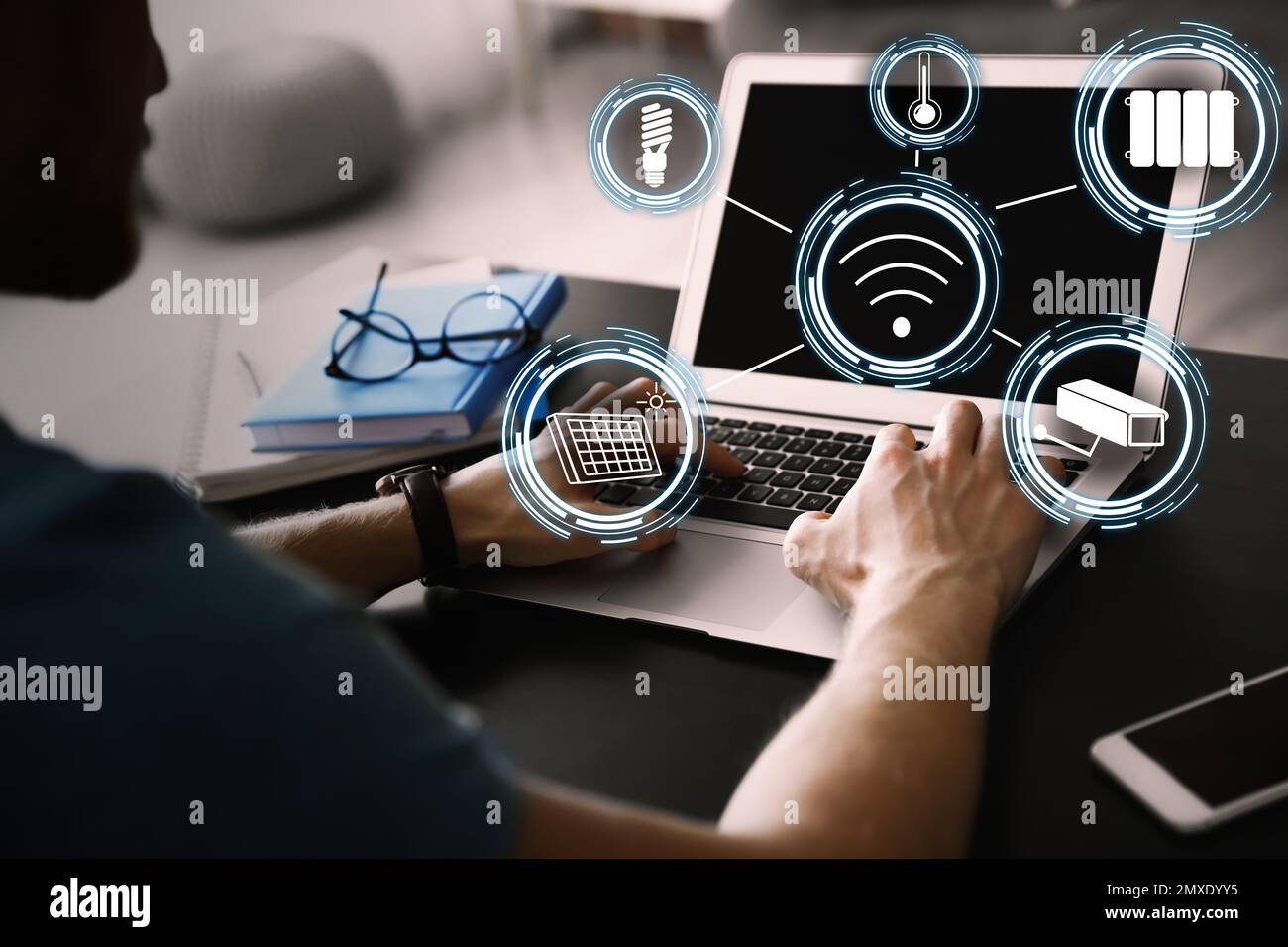 Homme utilisant un ordinateur portable pour contrôler la maison intelligente, gros plan. Systèmes automatiques Banque D'Images
