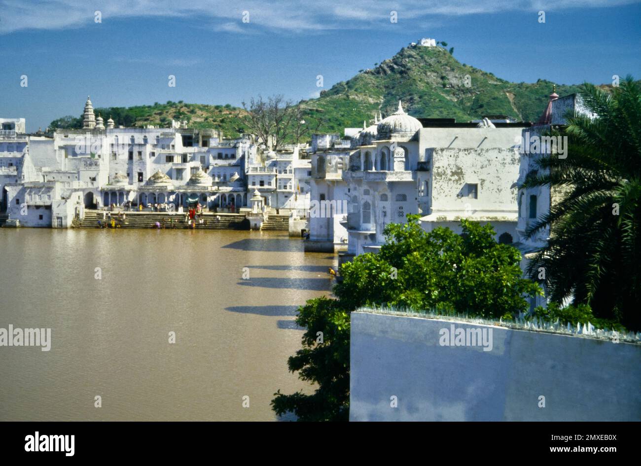 Historique, vue des archives des Ghats et des bâtiments entourant le lac sacré hindou Pushkar, Tirtha Raj, avec le temple Savitri Madri sur Une colline en arrière-plan, Pushkar, Inde 1990 Banque D'Images