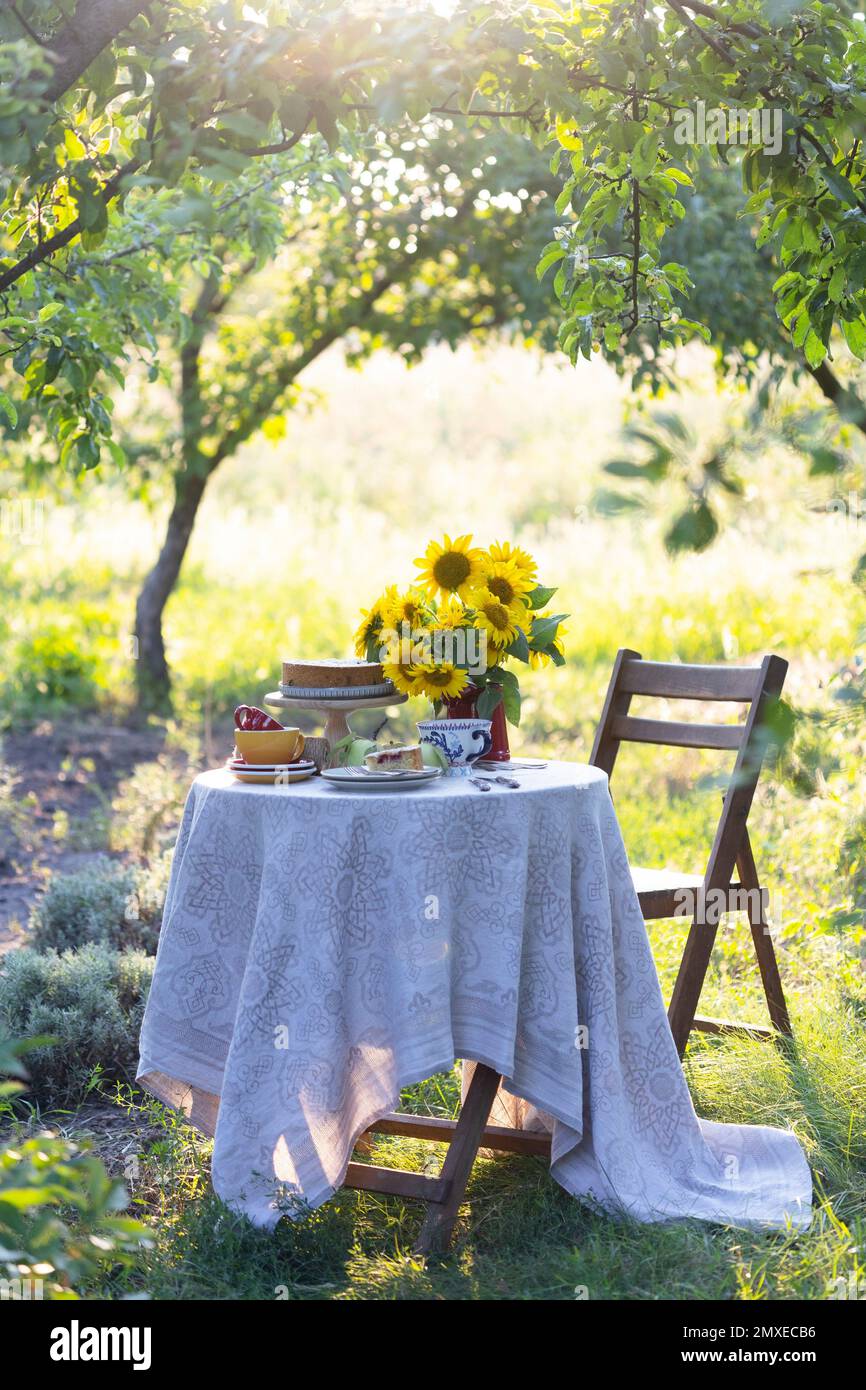 jardin et encore la vie. thé dans le jardin - tarte, vase avec tournesols et pommes sur une table Banque D'Images