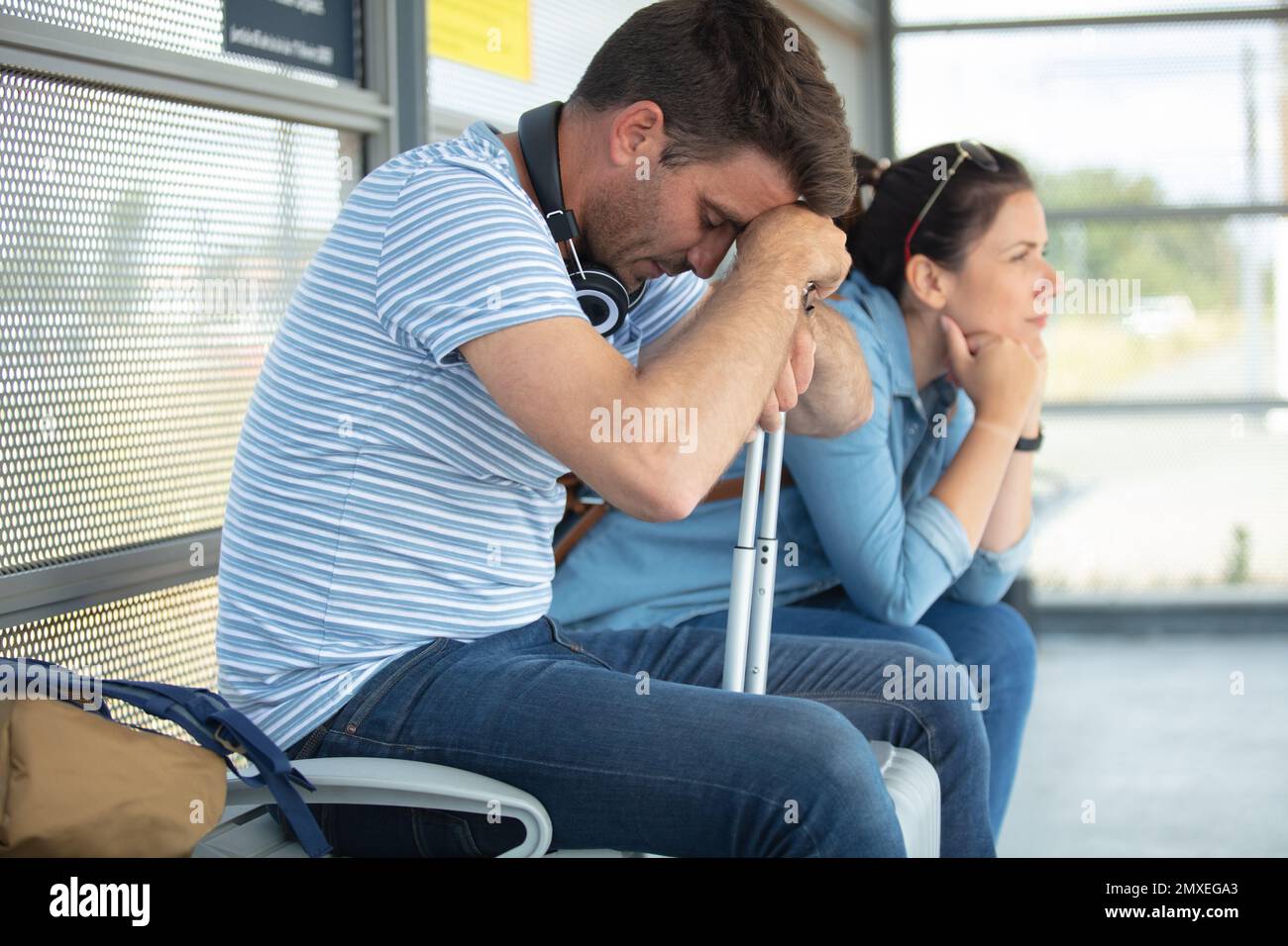 voyageurs déprimés qui attendent à la gare Banque D'Images