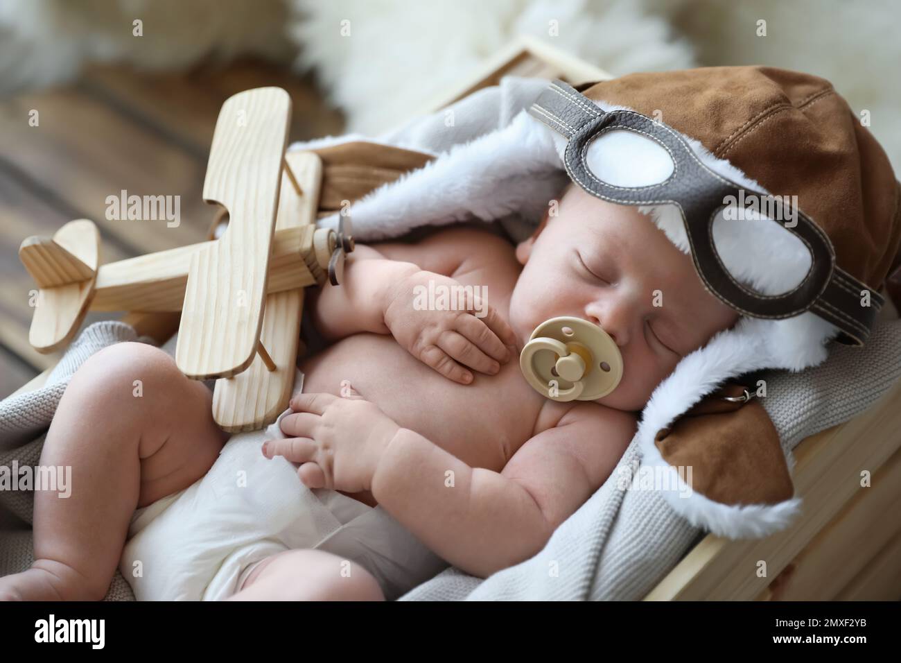 Bébé mignon nouveau-né portant un chapeau aviateur avec jouet dormir dans  une caisse en bois Photo Stock - Alamy