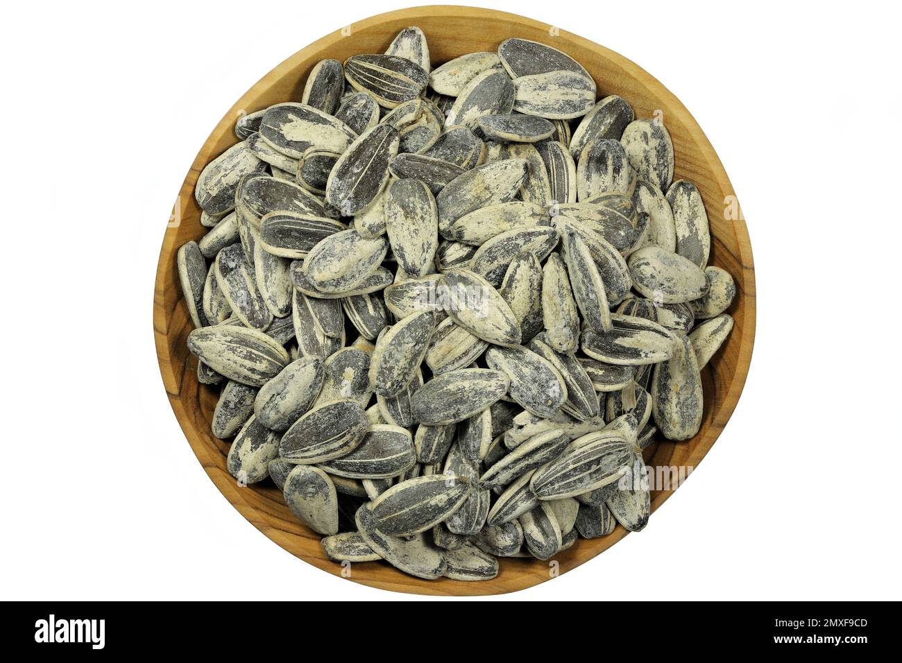 graines de tournesol entières grillées et salées dans un bol en bois d'olive isolé sur fond blanc Banque D'Images