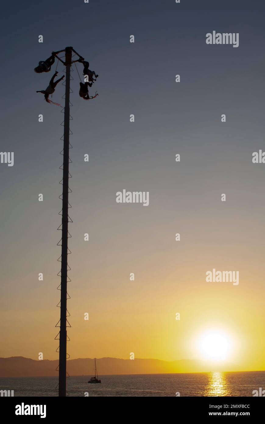 Une silhouette de personnes appréciant les Voladores de Papantla (les hommes volants) au coucher du soleil avec un paysage marin Viewconcept - respect et harmonie Banque D'Images