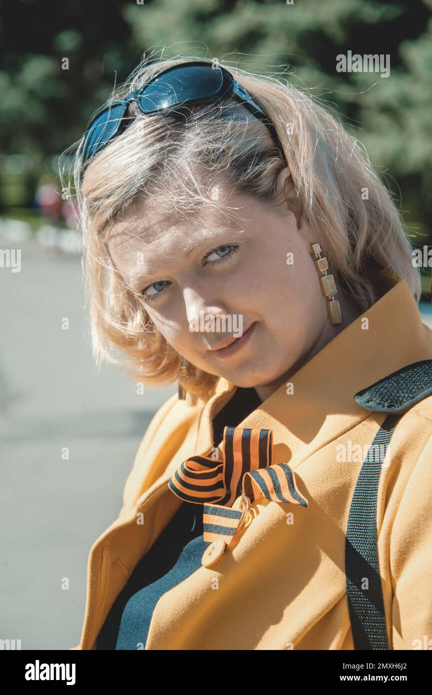 KOLOMNA, région de Moscou, Russie 9 mai 2014. Portrait d'une jeune femme en manteau jaune avec un St. George ruban pendant la préparation de la marche de Banque D'Images