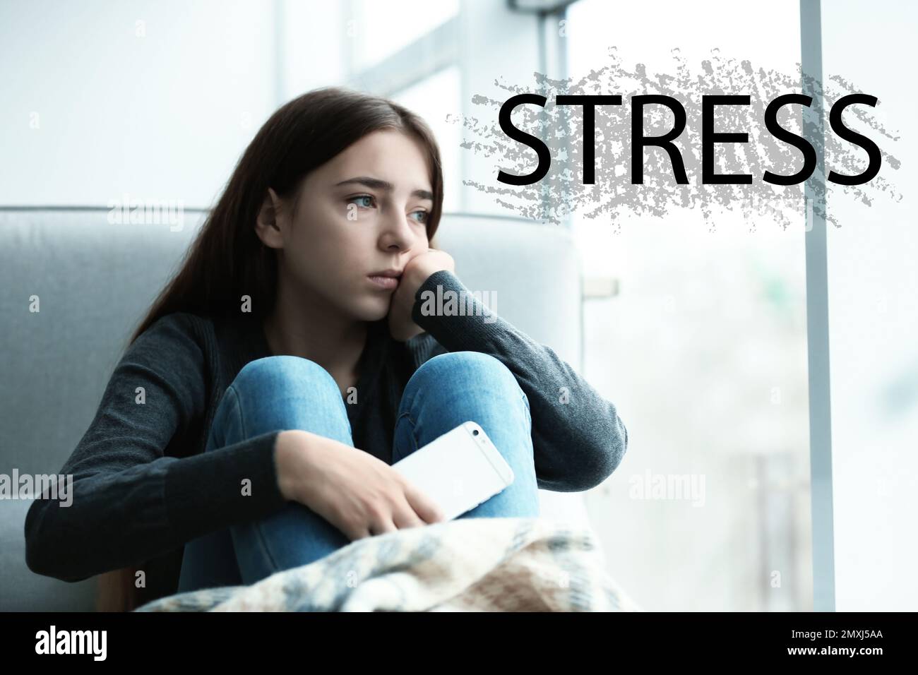 Mot STRESS et dépression jeune fille assis à la fenêtre à l'intérieur Banque D'Images