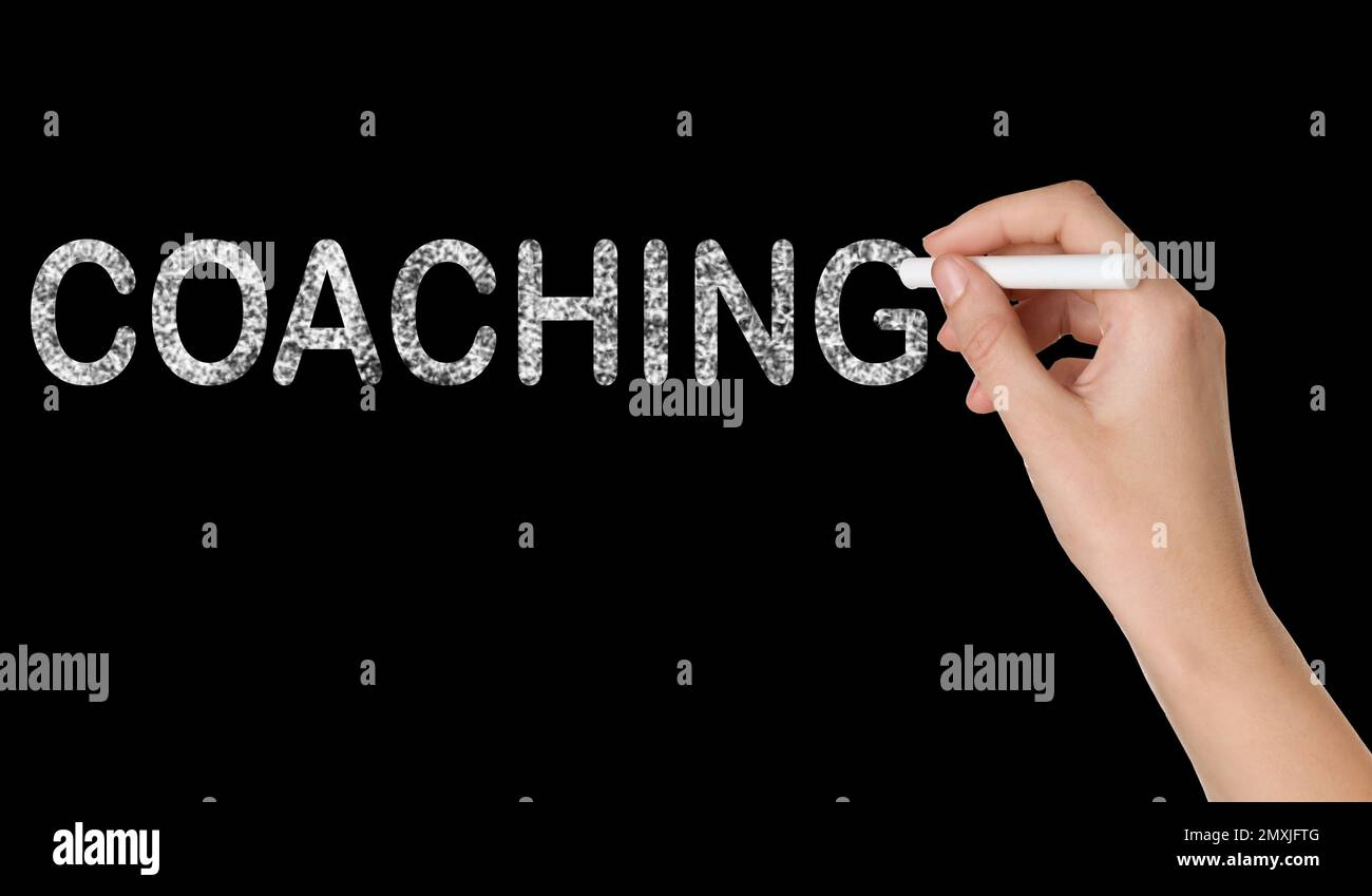 Entraîneur d'affaires ou de vie écrivant le mot Coaching sur le tableau noir, gros plan Banque D'Images