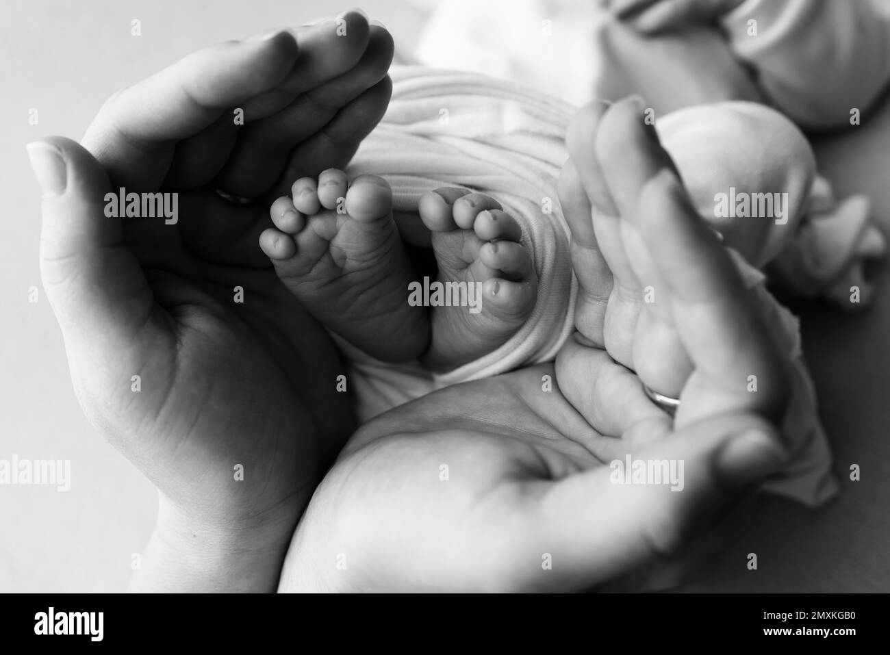 Les petits pieds d'un nouveau-né dans les mains de la mère. Main de paume aimantée d'une mère. Image concept de la maternité. Banque D'Images